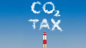 Carbon tax written in emissions smoke from a factory stack